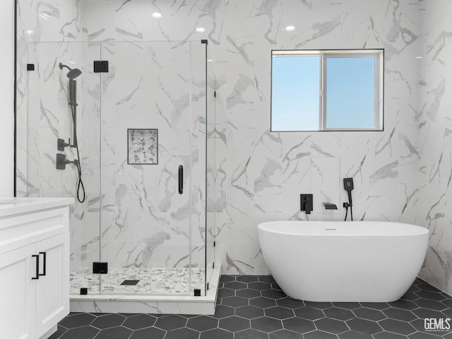 full bathroom featuring a marble finish shower, a freestanding bath, and vanity