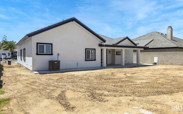 exterior space featuring central AC, a tiled roof, and stucco siding