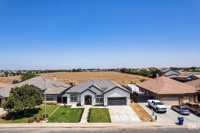 view of front facade with stucco siding, concrete driveway, a garage, a tiled roof, and a front lawn