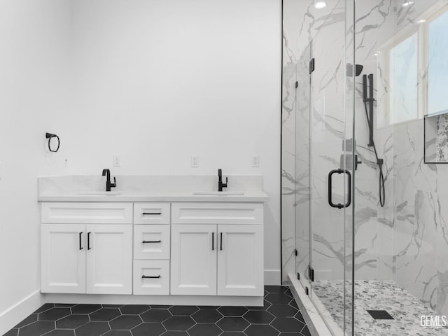 bathroom featuring tile patterned flooring, a sink, a marble finish shower, and double vanity