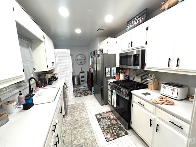 kitchen with sink, white cabinets, and stainless steel appliances