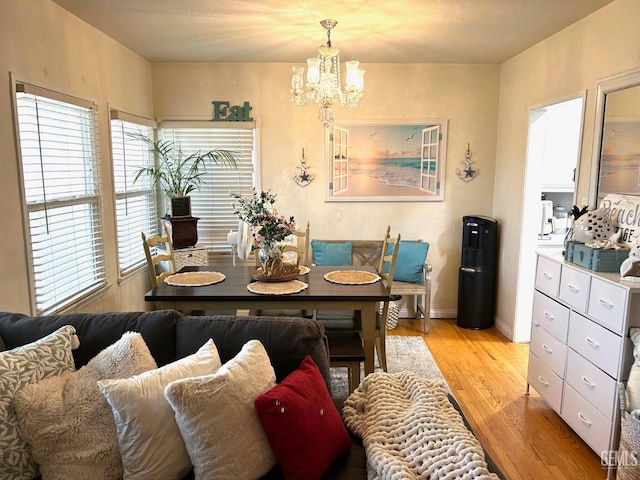 dining space with a wealth of natural light, light hardwood / wood-style flooring, and a chandelier