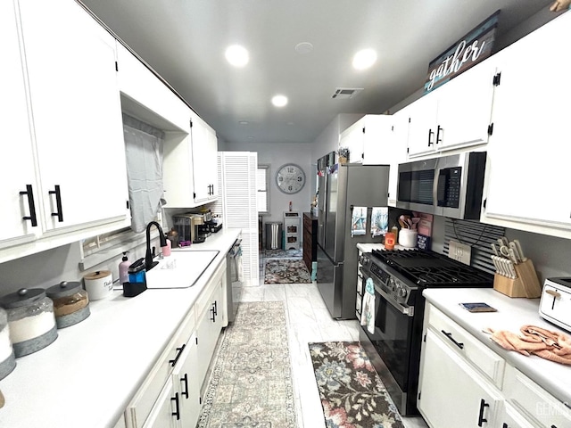 kitchen featuring sink, white cabinets, and stainless steel appliances