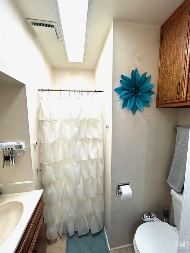 bathroom featuring curtained shower, toilet, and vanity