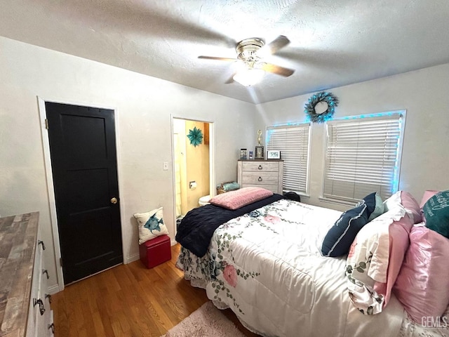 bedroom with ceiling fan, light hardwood / wood-style floors, and a textured ceiling