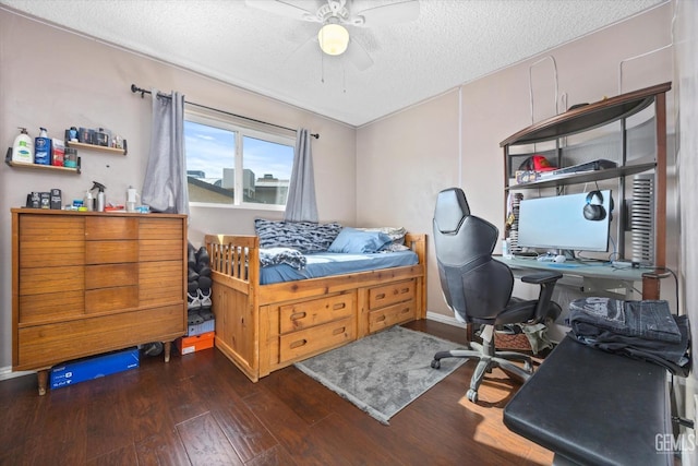 bedroom with a textured ceiling, ceiling fan, and dark hardwood / wood-style floors