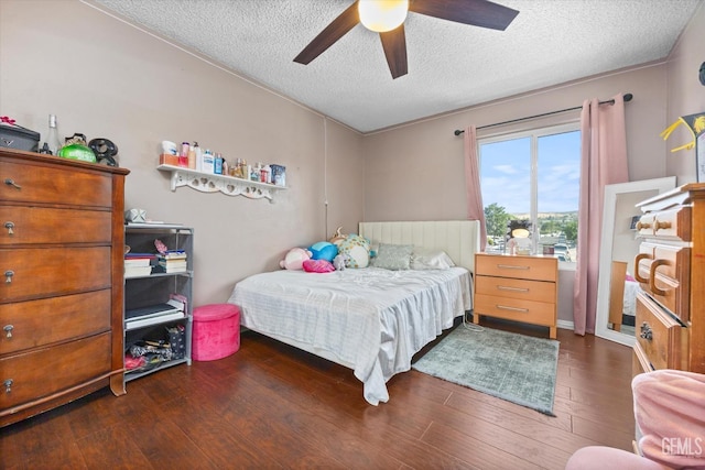 bedroom featuring ceiling fan, dark wood-type flooring, and a textured ceiling