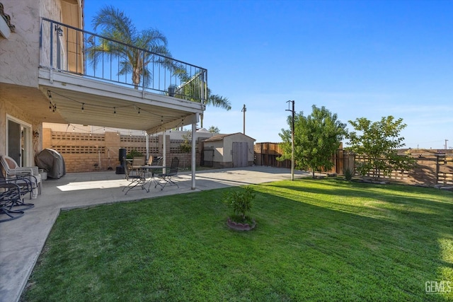 view of yard with a patio area, a balcony, and a storage shed