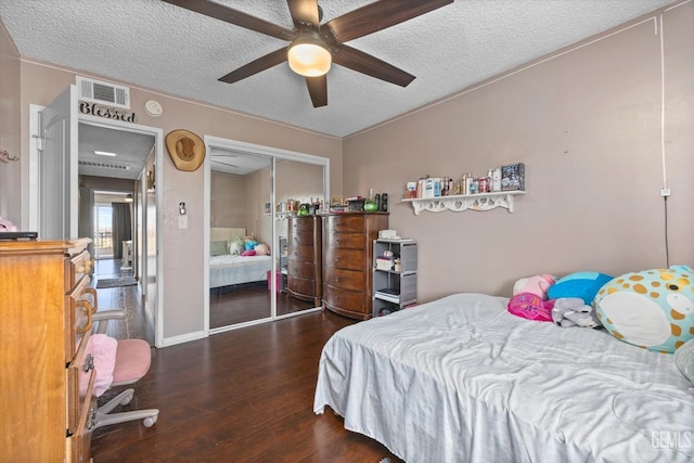 bedroom featuring a textured ceiling, dark hardwood / wood-style flooring, a closet, and ceiling fan