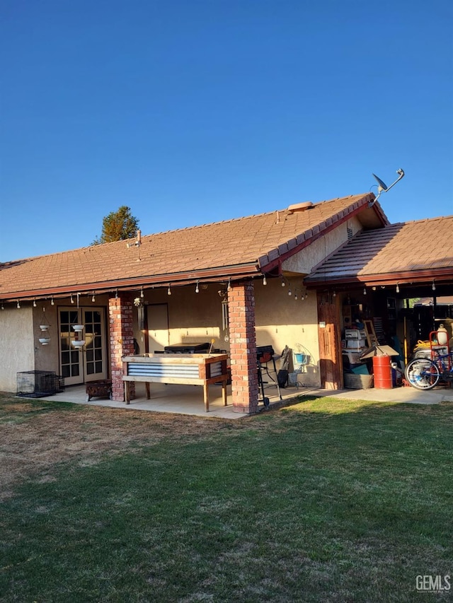 9101 Kern Island St, Bakersfield, CA 93307 - back of property featuring stucco siding, a lawn, and a patio area