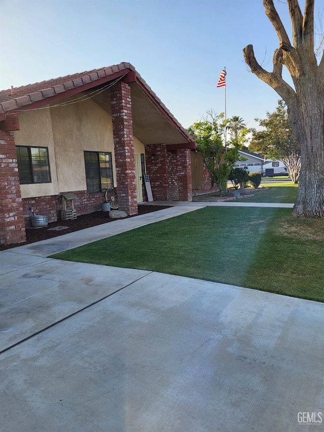 9101 Kern Island St, Bakersfield, CA 93307 - view of front of home with a front yard, stucco siding, and brick siding