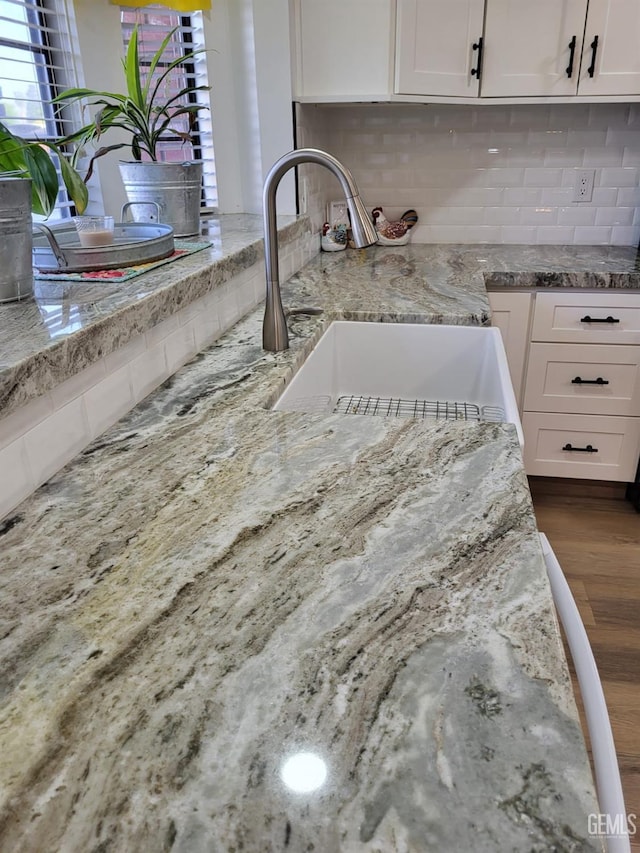 9101 Kern Island St, Bakersfield, CA 93307 - kitchen with light stone countertops, backsplash, wood finished floors, and white cabinets