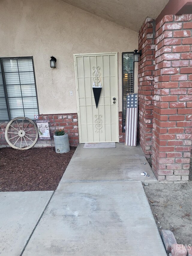 9101 Kern Island St, Bakersfield, CA 93307 - doorway to property featuring stucco siding and brick siding