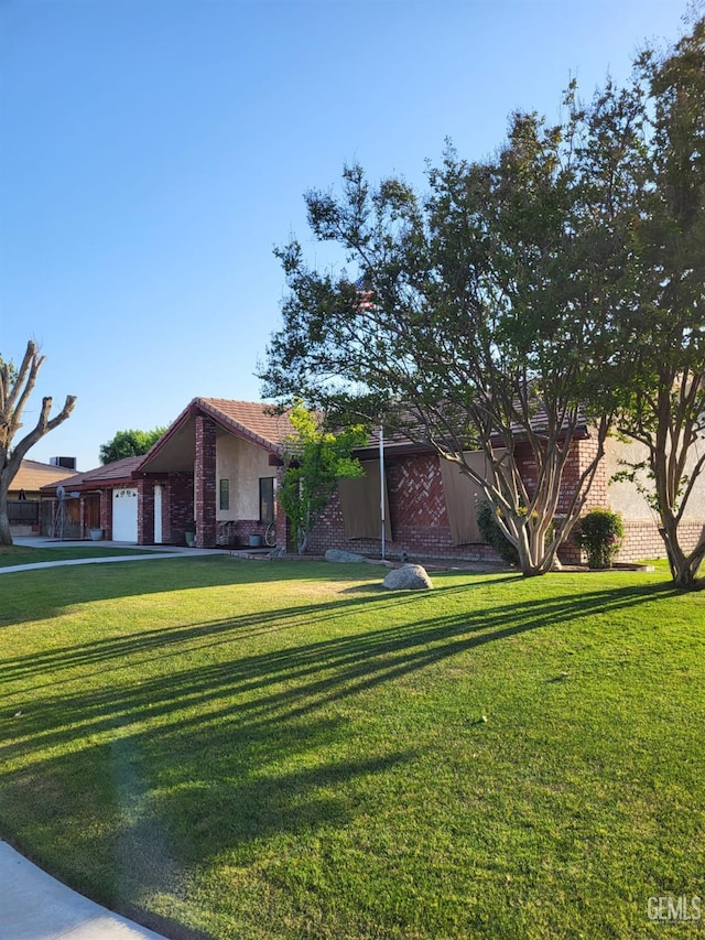 9101 Kern Island St, Bakersfield, CA 93307 - view of front of house featuring an attached garage, a front yard, and brick siding
