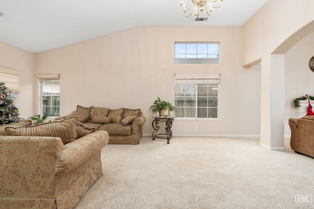 carpeted living room with a notable chandelier