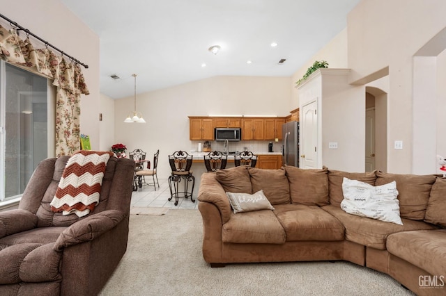 living room featuring a notable chandelier, light tile patterned flooring, and vaulted ceiling