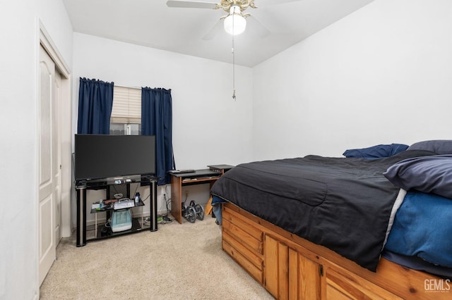 bedroom featuring a closet, light colored carpet, and ceiling fan