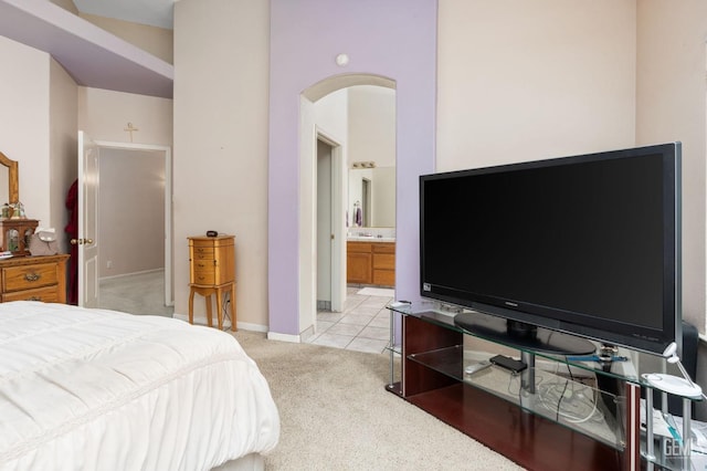 bedroom featuring light colored carpet and ensuite bath