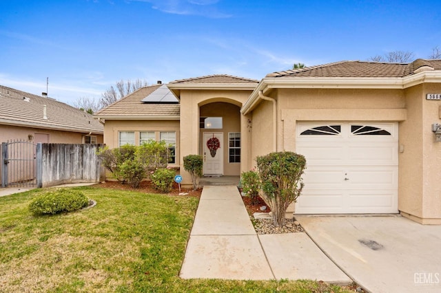 view of front of property featuring a garage, a front yard, and solar panels