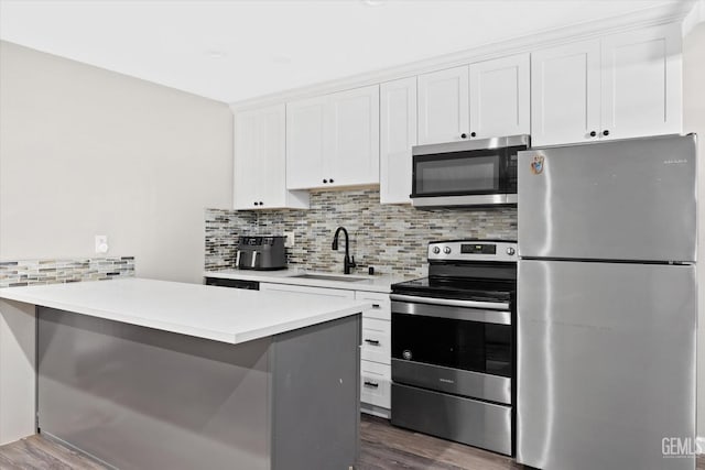 kitchen with tasteful backsplash, dark wood-style flooring, a sink, and stainless steel appliances