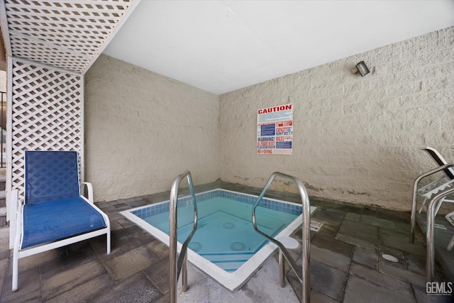 view of pool with a patio area and an indoor hot tub
