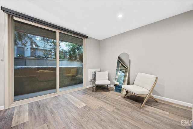 living area with arched walkways, baseboards, and wood finished floors