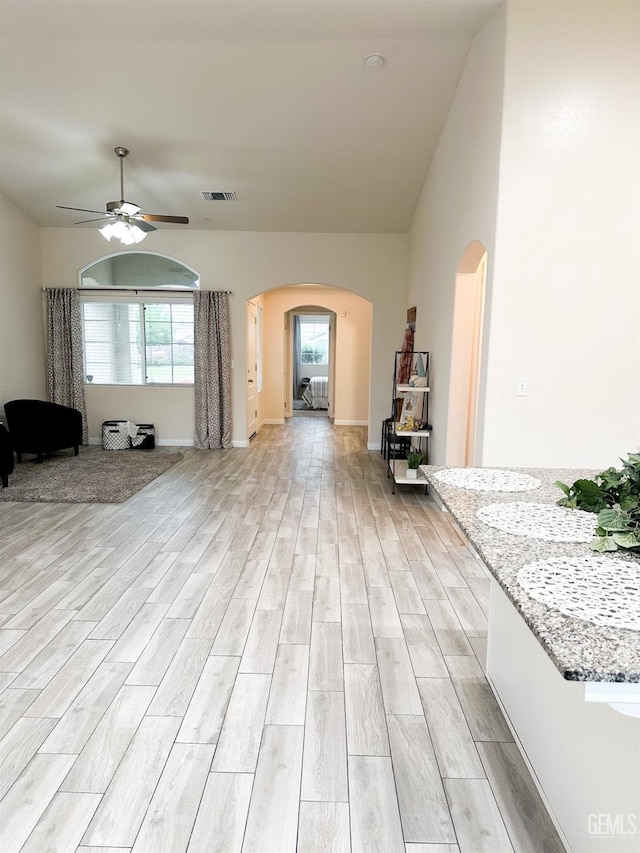 9400 Carriage Creek Ct, Bakersfield, CA 93311 - living room featuring arched walkways, light wood-style floors, ceiling fan, and baseboards