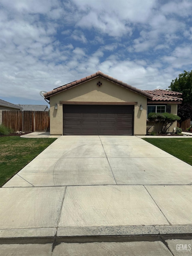 9400 Carriage Creek Ct, Bakersfield, CA 93311 - mediterranean / spanish home featuring concrete driveway, stucco siding, a garage, and fence