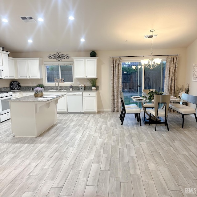 9400 Carriage Creek Ct, Bakersfield, CA 93311 - kitchen featuring white appliances, light wood-type flooring, a chandelier, white cabinets, and recessed lighting
