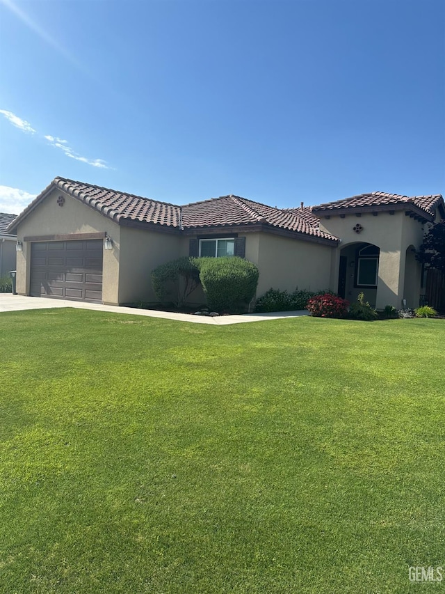 mediterranean / spanish-style home with a garage, stucco siding, a tile roof, and a front yard