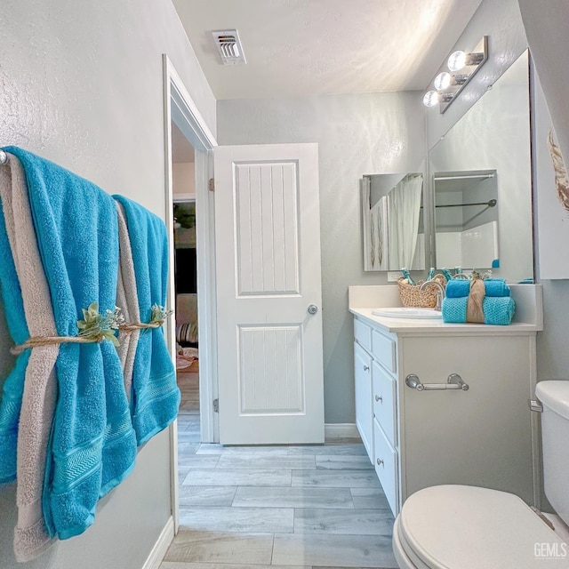 9400 Carriage Creek Ct, Bakersfield, CA 93311 - bathroom featuring toilet, vanity, wood finished floors, and baseboards