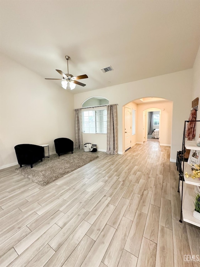 9400 Carriage Creek Ct, Bakersfield, CA 93311 - living area featuring arched walkways, light wood finished floors, a ceiling fan, and baseboards