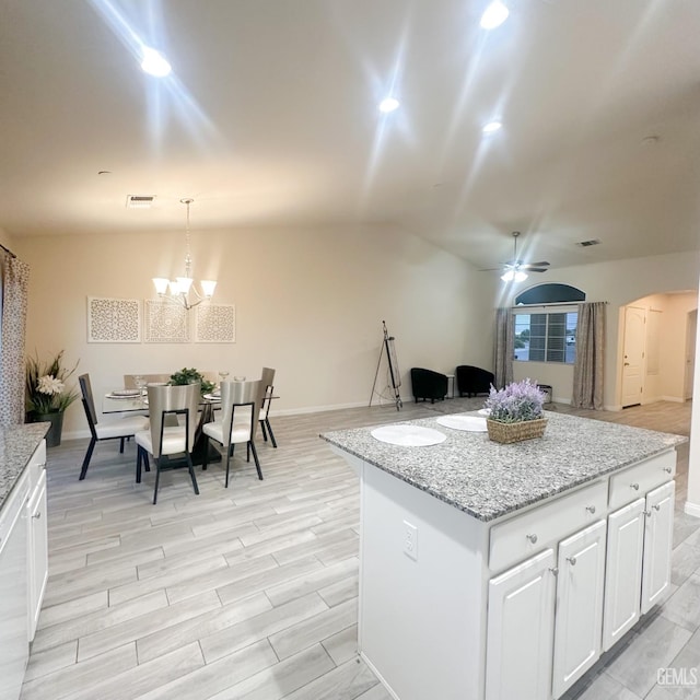 9400 Carriage Creek Ct, Bakersfield, CA 93311 - kitchen with white cabinetry, a center island, ceiling fan, lofted ceiling, and hanging light fixtures