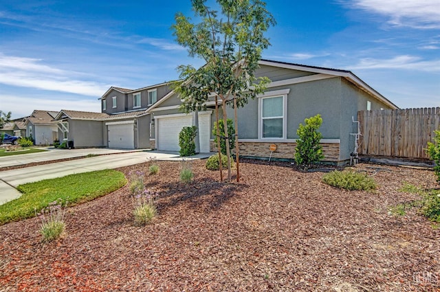 6003 Vespucci Ave, Bakersfield, CA 93313 - view of front facade featuring stucco siding, driveway, stone siding, and an attached garage
