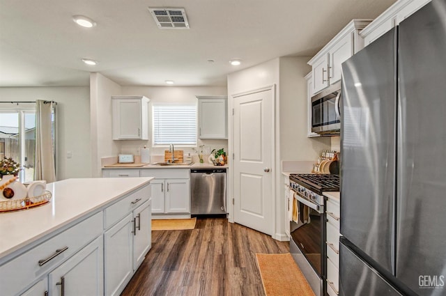 6003 Vespucci Ave, Bakersfield, CA 93313 - kitchen featuring appliances with stainless steel finishes, dark wood-type flooring, light countertops, white cabinets, and recessed lighting