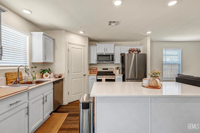 6003 Vespucci Ave, Bakersfield, CA 93313 - kitchen with appliances with stainless steel finishes, light countertops, dark wood-style floors, recessed lighting, and white cabinets