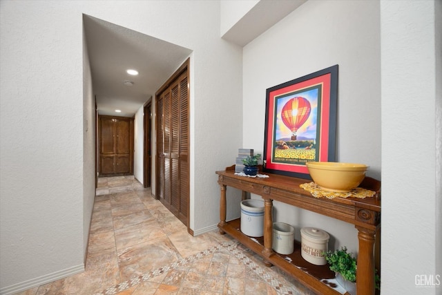 corridor with a textured wall and baseboards