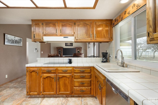 kitchen featuring a peninsula, stainless steel dishwasher, brown cabinetry, and black electric stovetop