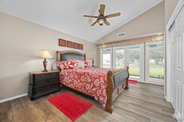 bedroom featuring lofted ceiling, ceiling fan, wood finished floors, visible vents, and baseboards