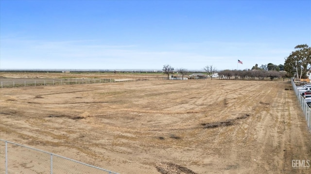 view of yard featuring fence and a rural view