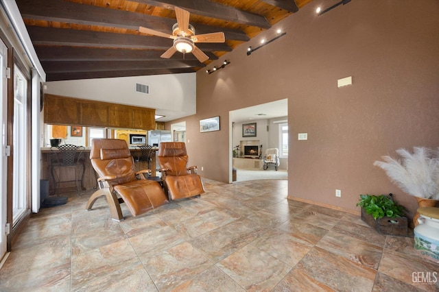 interior space with visible vents, wooden ceiling, lofted ceiling with beams, a warm lit fireplace, and stainless steel fridge with ice dispenser