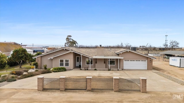 view of front of house with concrete driveway, a fenced front yard, a chimney, and stucco siding