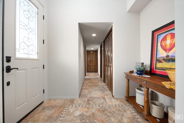 foyer entrance featuring stone finish flooring and baseboards