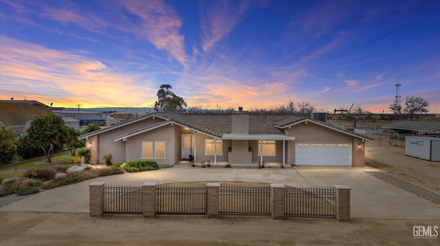 view of front of home with a fenced front yard, driveway, a garage, and stucco siding