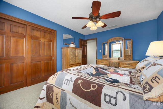 bedroom with ceiling fan, a textured ceiling, visible vents, and carpet flooring