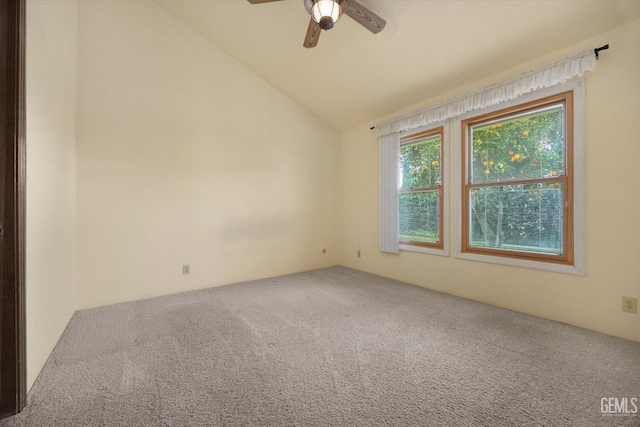 empty room featuring lofted ceiling, carpet floors, and ceiling fan