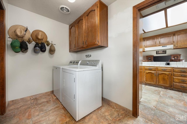 washroom featuring cabinet space, washing machine and clothes dryer, visible vents, and baseboards