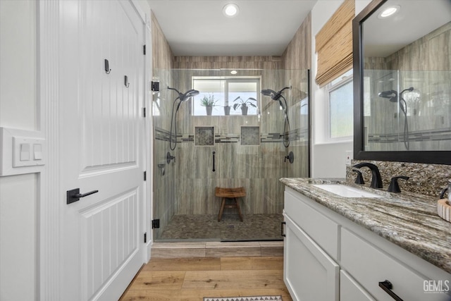 full bathroom with a stall shower, vanity, recessed lighting, and wood finished floors