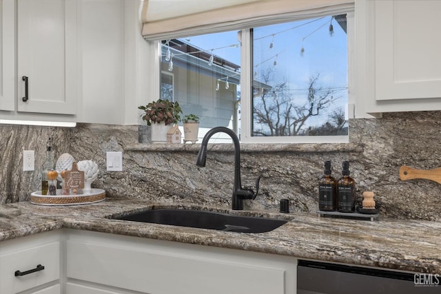 kitchen with white cabinets, a sink, backsplash, and dishwasher