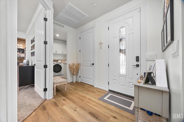 entryway featuring light wood-type flooring, washer / clothes dryer, visible vents, and baseboards